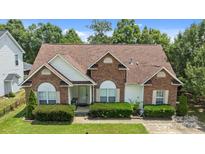 Charming brick home with a well-manicured lawn and mature landscaping offers great curb appeal at 5508 Burning Ridge Dr, Monroe, NC 28110