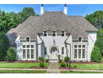Striking white painted brick home with well manicured lawn and stone pathway to front door at 6314 Saint Stephen Ln, Charlotte, NC 28210