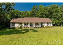 Charming ranch home with a covered porch, lush lawn, and mature trees at 637 Freemont Dr, Lancaster, SC 29720
