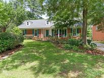 Charming brick home with lush lawn, mature trees, and inviting curb appeal at 7118 Powder Mill Pl, Charlotte, NC 28277