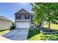 Charming two-story home featuring a two-car garage, well-manicured lawn, and a welcoming front porch at 722 Overlook Rd, Lowell, NC 28098