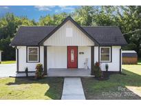Charming one-story home featuring a red front door, black roof, and a well-manicured lawn at 803 Irene Ave, Kannapolis, NC 28083