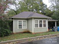 Charming home featuring light green horizontal siding, a covered side porch and mature landscaping at 9 Poplar St, Belmont, NC 28012