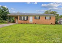 Charming brick home featuring a well-manicured lawn and covered carport at 1019 Carmel Dr, Gastonia, NC 28056