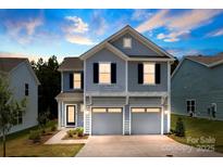 Charming two-story home featuring a two-car garage, light blue siding and a welcoming entrance at twilight at 11195 Argosy Dr # 1098, Lancaster, SC 29720