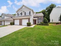 Two-story townhome featuring a well-maintained lawn and a two-car garage at 12415 Stratfield Place Cir, Pineville, NC 28134