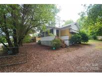 Quaint single-story home with a covered porch and mature landscaping at 1409 Turner Dr, Gastonia, NC 28052
