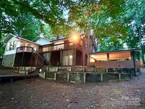 Beautiful exterior with wooden deck, brick features, and lush surrounding trees at 143 Uwharrie Ct # 10801081, Mount Gilead, NC 27306