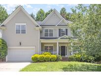 Charming two-story home featuring a manicured front yard, attached garage, and classic architectural details at 14333 Maclauren Ln, Huntersville, NC 28078