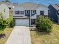 Charming two-story home with stone accents, red shutters, and a well-manicured lawn at 15119 Oleander Dr, Charlotte, NC 28278