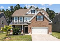 Charming two-story home featuring a brick and siding exterior, a well-manicured lawn, and an attached two-car garage at 169 Rooster Tail Ln, Troutman, NC 28166