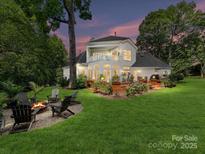 Expansive backyard featuring a fire pit and beautiful landscaping, perfect for outdoor entertaining at 19205 Hidden Cove Ln, Cornelius, NC 28031
