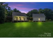 Charming exterior of a well-maintained home with a large yard and separate garage at 220 Plonk Rd, Dallas, NC 28034