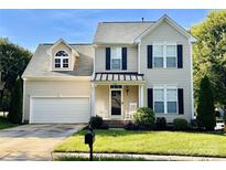 Charming two-story home with a well-manicured lawn, two-car garage, and inviting front porch with rocking chairs at 3301 Old Knobbley Oak Dr, Gastonia, NC 28056