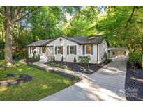 Charming home featuring a landscaped front yard with a stone pathway leading to the entrance at 3519 Campbell Dr, Charlotte, NC 28205