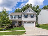 Charming two-story home with stone accents, a two-car garage, and a well-manicured front lawn at 4014 Stockbrook Dr, Charlotte, NC 28215
