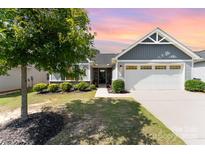 Charming single-story home featuring a two-car garage, well-manicured lawn, and beautiful landscaping at 4227 Mackinnon Dr, Charlotte, NC 28214