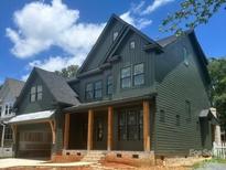Two story dark green home with a covered porch and garage showing its craftsman architecture at 427 Greystone Rd, Charlotte, NC 28209