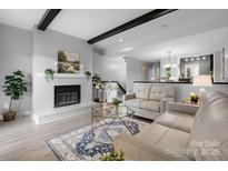 Cozy living room features a fireplace, wood beams, and an open layout to the dining area at 5192 Corbin Ln, Hickory, NC 28601