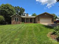 Charming single-story brick home featuring a well-manicured lawn and stone chimney at 5238 Bethel Church Rd, Hickory, NC 28602