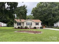 Charming single-story home with manicured lawn, landscaping, and a quaint front porch at 618 Springfield Nw Dr, Concord, NC 28027