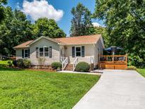 Charming single-story home featuring a well-maintained lawn and inviting front porch, with a driveway on a sunny day at 618 Springfield Nw Dr, Concord, NC 28027