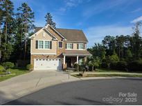 Charming two-story home featuring stone accents, a well-manicured lawn, and a convenient two-car garage at 6412 Bluegill Rd, Charlotte, NC 28216