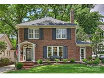 Charming brick home with black shutters, a well-manicured lawn, and a welcoming front porch and walkway at 726 E Kingston Ave, Charlotte, NC 28203
