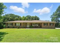 Charming single-story brick home featuring a large, well-maintained front yard and mature trees at 900 Nance St, Kannapolis, NC 28083