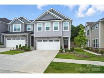 Charming two-story home with stone accents, gray siding, and a well-manicured lawn at 11246 Bartrams Way, Charlotte, NC 28278