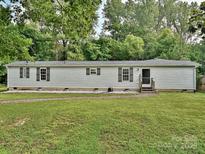 Charming one-story home with a well-manicured lawn and lovely landscaping at 1140 Randall Ct, Concord, NC 28025