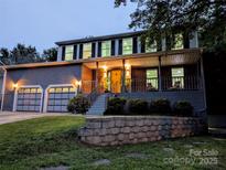 Charming two-story home featuring an attached two-car garage and a welcoming front porch with a yellow door at 11419 Leadenhall Ln, Charlotte, NC 28262