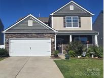 Charming two-story home with stone accents, a two-car garage, and a well-maintained front yard at 1220 Kent Downs Sw Ave, Concord, NC 28027