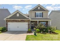 Charming home with a stone and siding exterior, a well-manicured lawn, and a cozy front porch at 1220 Kent Downs Sw Ave, Concord, NC 28027