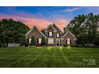 Charming brick home with manicured lawn and landscaping, enhanced by beautiful sunset tones at 1236 James Farm Rd, Hickory, NC 28602