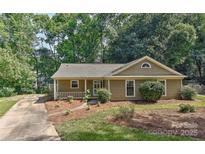 Charming single story home featuring a cozy front porch and mature trees at 2706 Bremer Ct, Charlotte, NC 28210