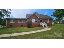 Charming brick home featuring a well-manicured lawn and inviting blue front door at 2828 Bellhaven Cir, Charlotte, NC 28214