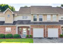 Charming townhome with brick facade, attached garages, manicured lawn, and inviting curb appeal at 349 Valley Brook Se Ln, Concord, NC 28025