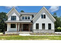 Charming two-story home with white siding, black trim windows, stone accents and covered front porch at 537 Riddle Mill Rd, Clover, SC 29710