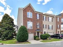 Charming brick townhome featuring an attached garage and manicured landscaping at 7518 Turley Ridge Ln, Charlotte, NC 28273