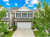 Charming two-story townhome featuring a two-car garage, stone accents, and well-maintained landscaping at 921 Summerlake Dr, Fort Mill, SC 29715