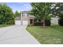 Charming two-story home featuring a two-car garage, well-manicured lawn, and mature trees at 1210 Tabitha Ct, Monroe, NC 28110
