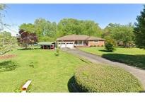 Charming home featuring a spacious yard and a long driveway leading to a two-car garage at 128 Howie St, Mount Holly, NC 28120