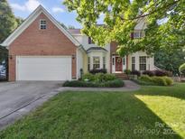 Charming two-story traditional-style home with a brick facade, attached garage, and manicured lawn at 130 Nims Spring Dr, Fort Mill, SC 29715