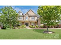 Charming brick home featuring a well-manicured lawn, landscaped garden and a covered front porch at 13519 Crystal Springs Dr # 148, Huntersville, NC 28078