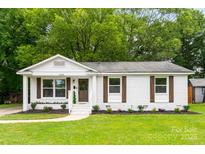 Charming single-story home featuring a well-maintained lawn and beautifully painted white brick at 1426 Larkfield Ln, Charlotte, NC 28210