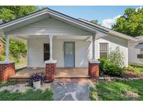 Charming home with a covered front porch featuring brick pillars and a light blue door at 1626 W Park Ave, Albemarle, NC 28001