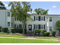 Inviting townhome featuring a well-maintained lawn and classic black shutters at 504 Wakefield Dr # A, Charlotte, NC 28209