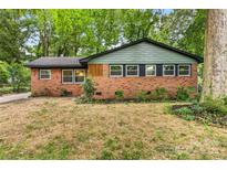 Charming brick home with a modern roof, large windows, and lush landscaping at 5320 Kildare Dr, Charlotte, NC 28215