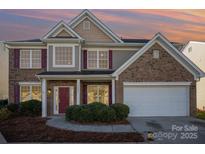 Charming two-story home features a brick and siding exterior, a two-car garage, and a well-manicured lawn at 5805 Lindley Crescent Dr, Indian Trail, NC 28079